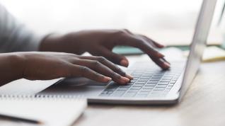 A person typing on a laptop. 